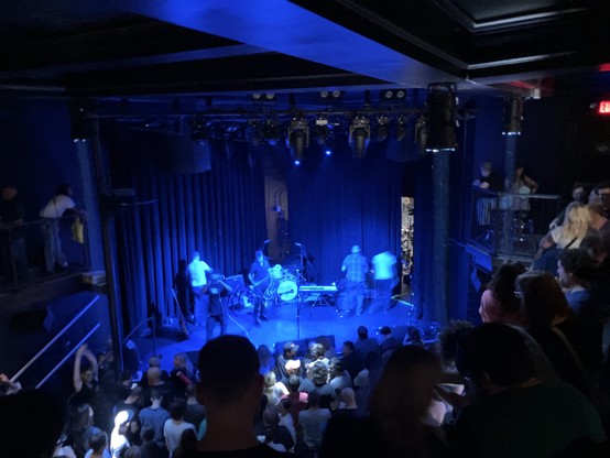 Photo of a band (The Dismemberment Plan) setting up onstage at The Atlantis in Washington DC. 